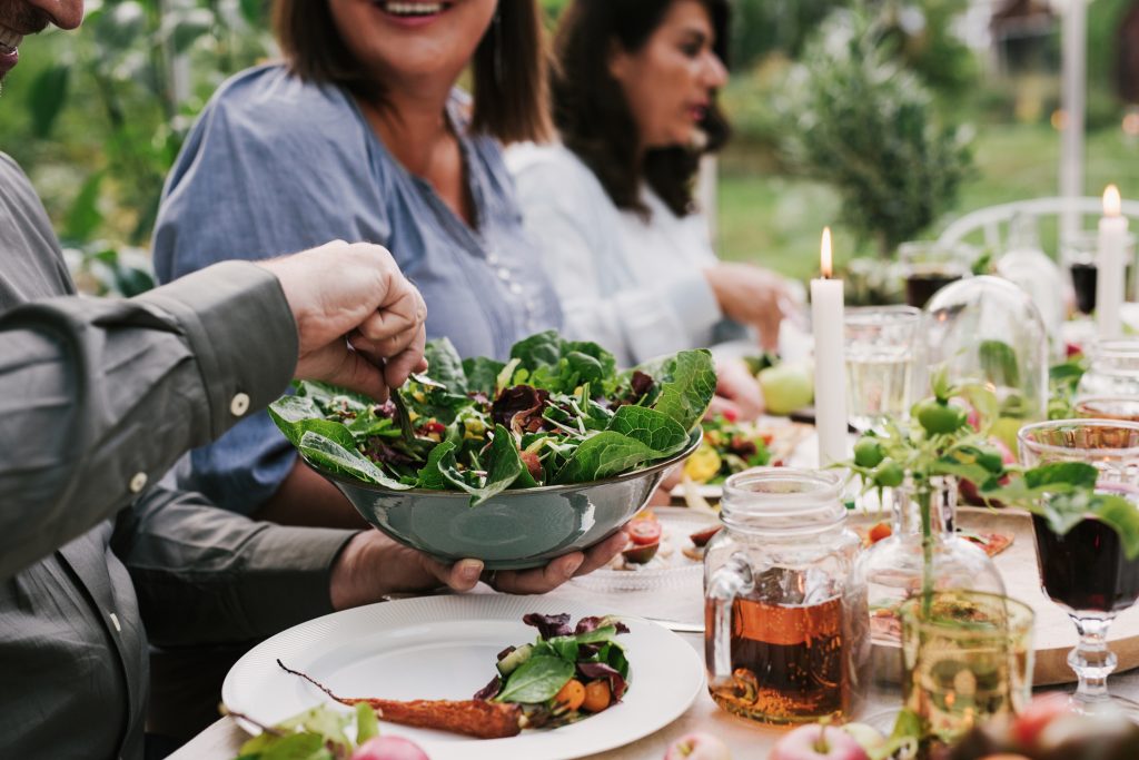 Family having dinner and salad outdoors