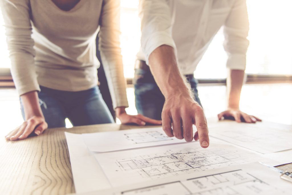 Cropped image of beautiful business couple examining drafts while working in office